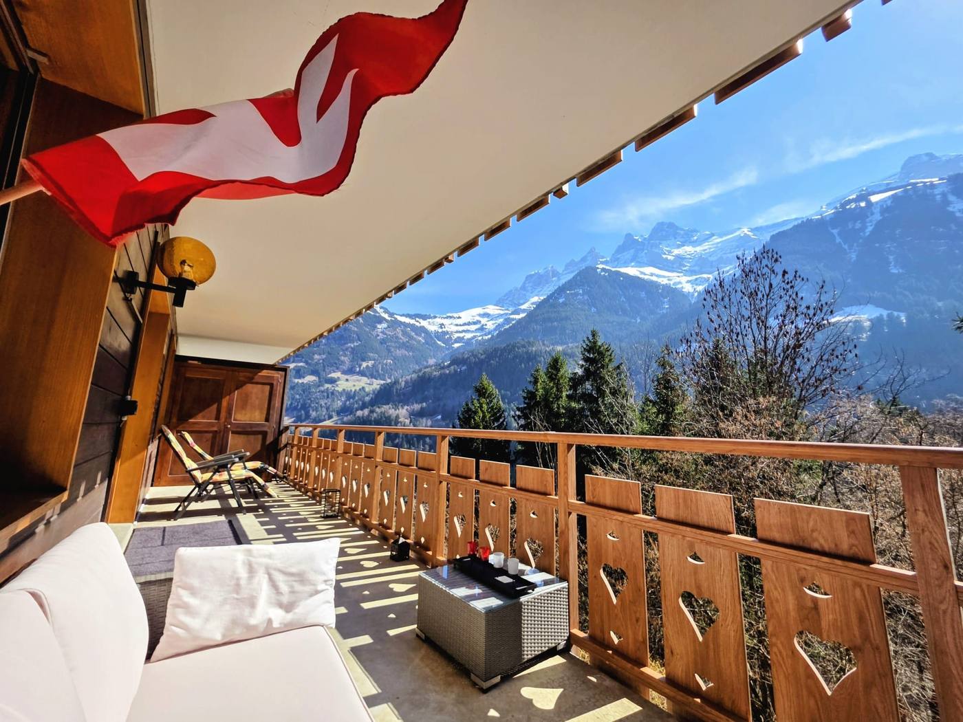 Terrasse mit Schweizer Fahne und Bergpanorama