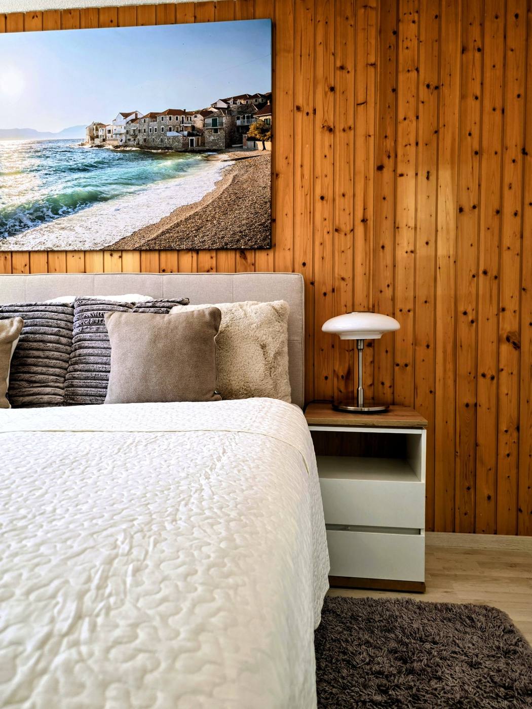 Frisch bezogenes Kingsize-Bett mit weisser Tagesdecke