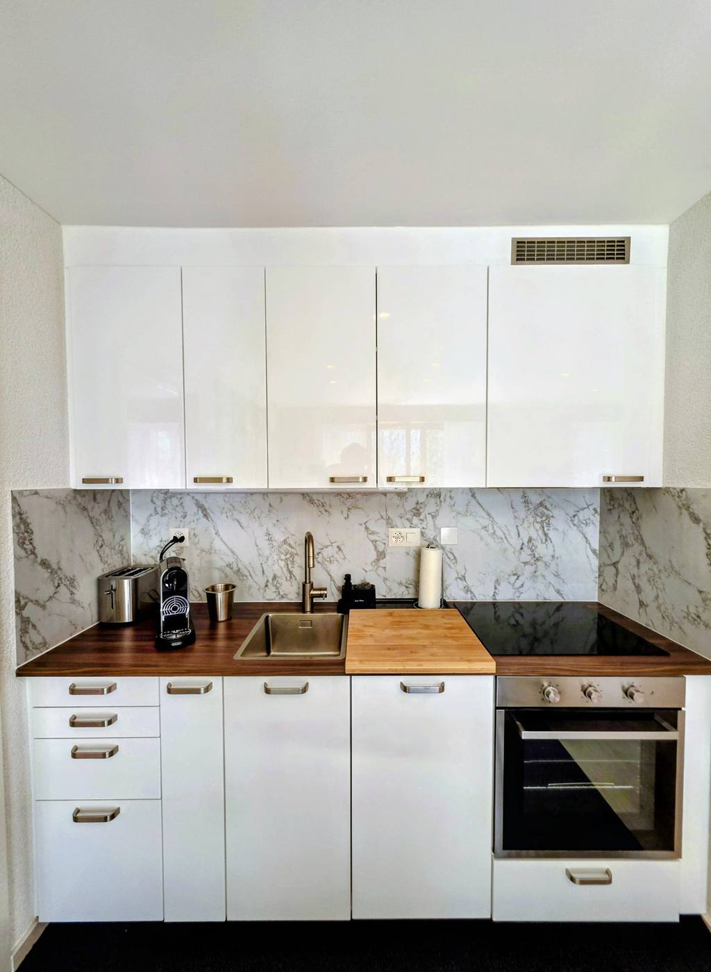 Küche mit Marmorrückwand, Backofen und Nespresso