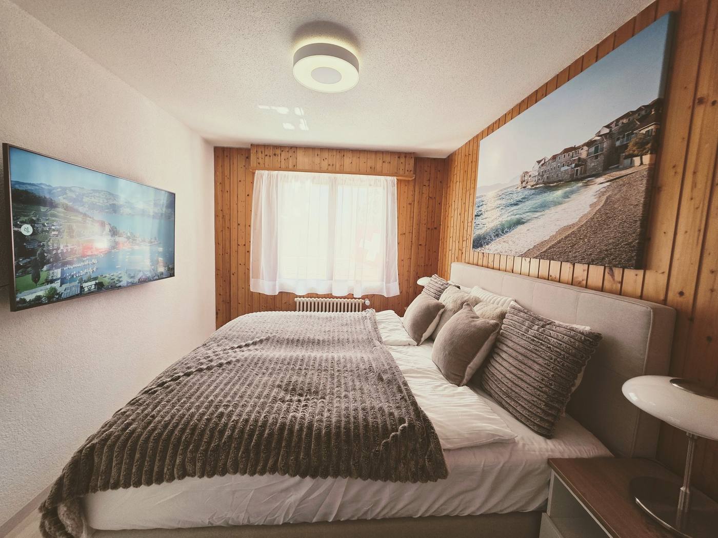 Schlafzimmer mit Kingsize-Bett und Smart-TV